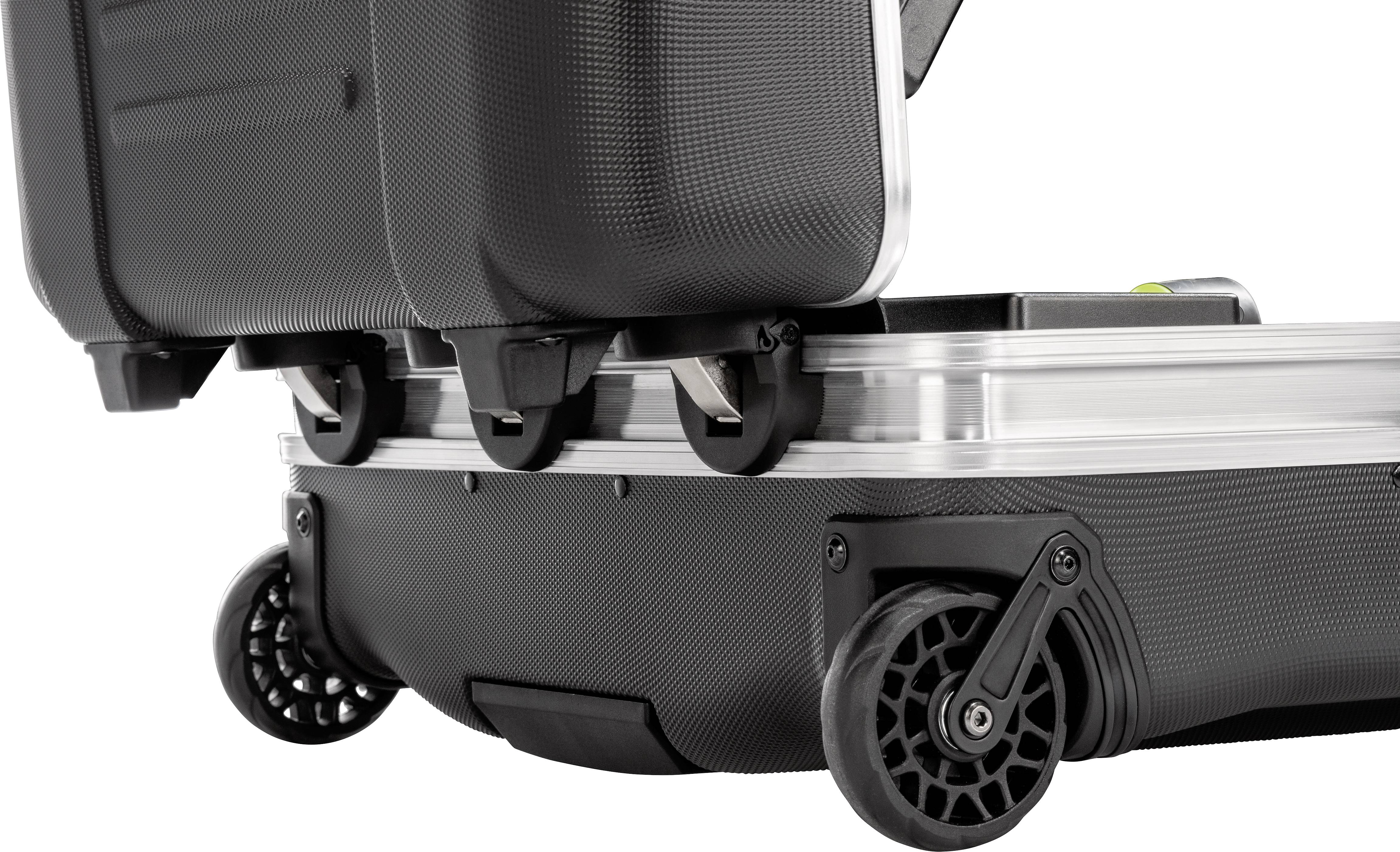 A black wheeled suitcase with robust wheels and silver framework is partially shown open.