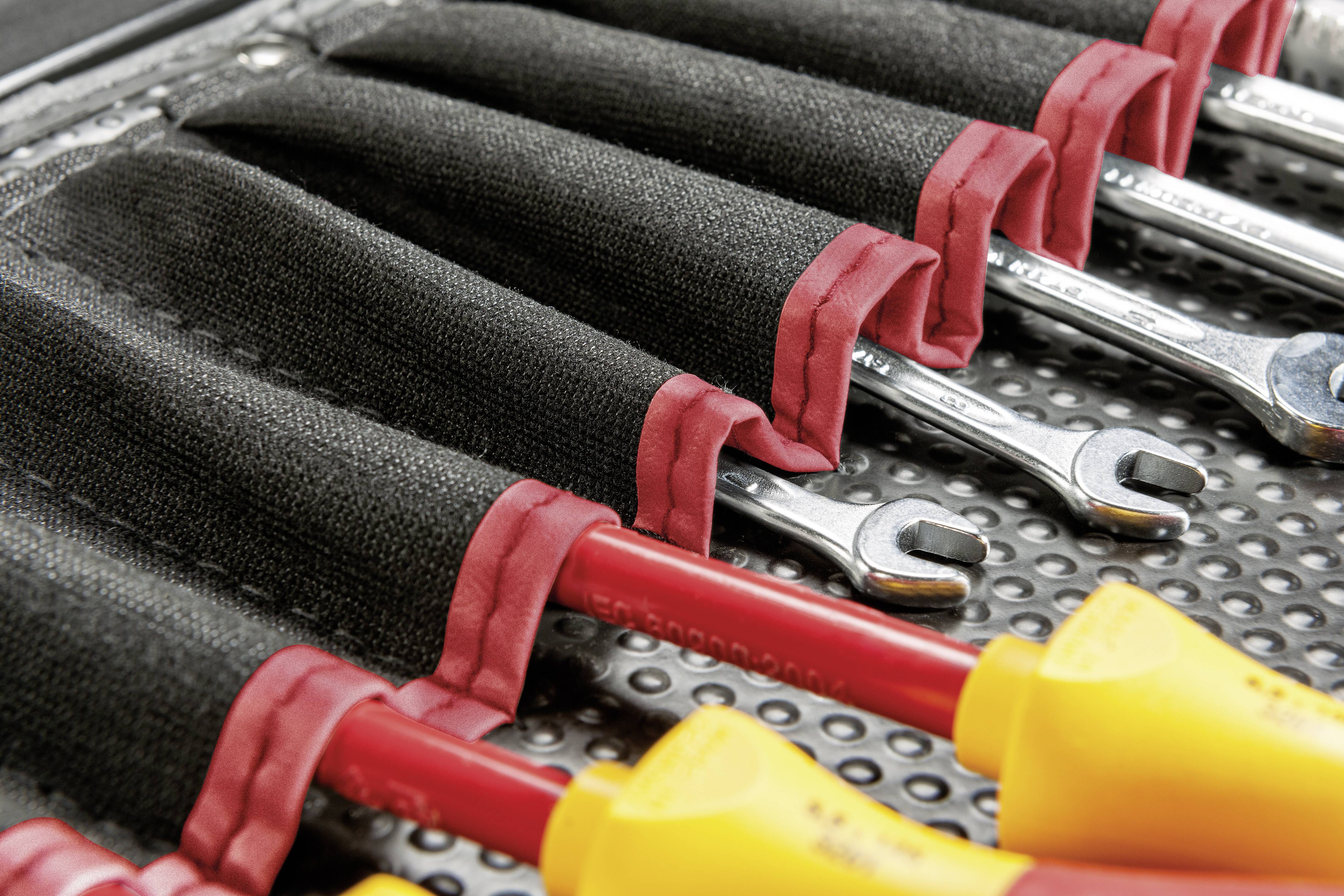 Tool set with insulated screwdrivers and spanners in an organised holder, ready for use.
