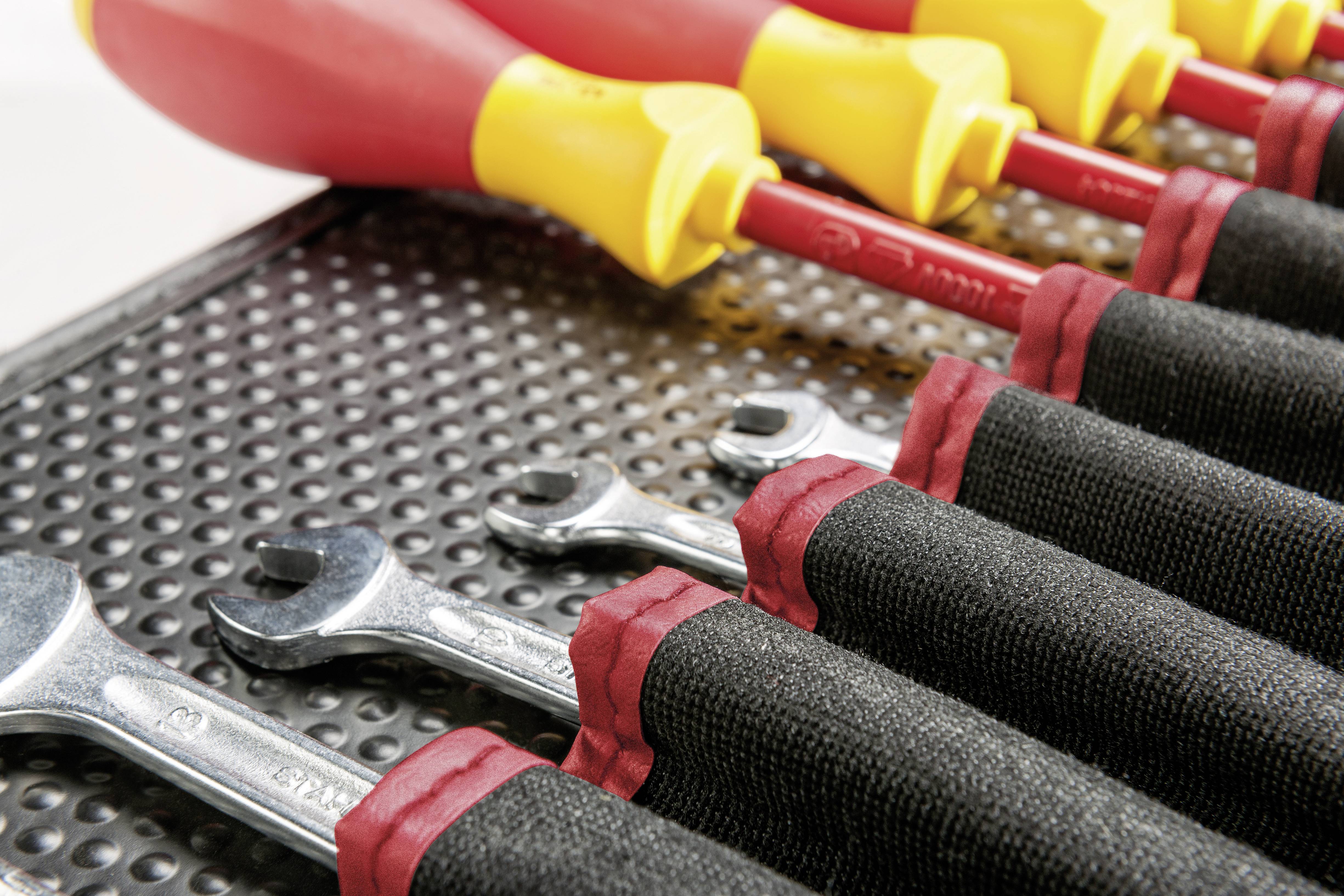 Close-up of spanners and screwdrivers in a tool bag. Organised arrangement on a dotted surface.