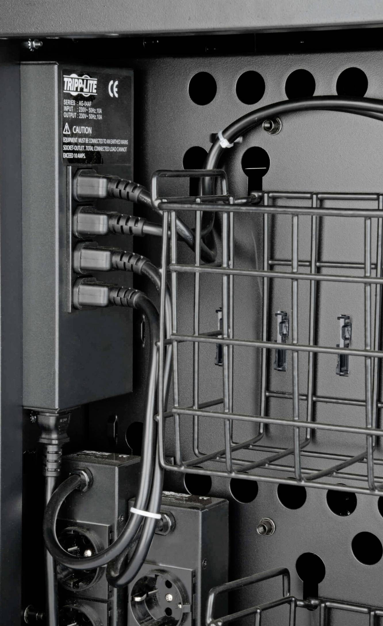 Tripp Lite device with multiple power cable connections and a wire basket for cable management in a technical environment.