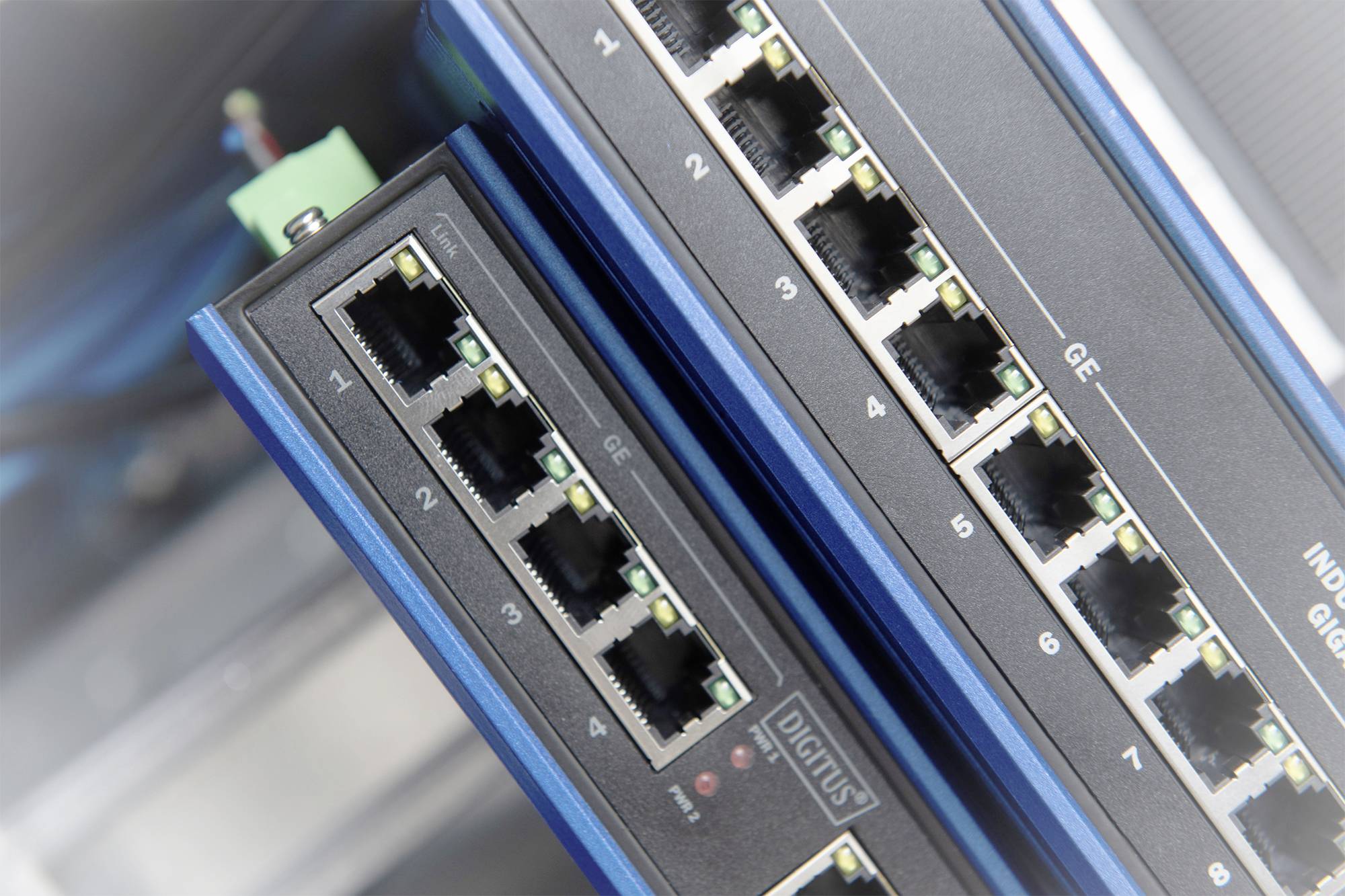 Two network switches with multiple Ethernet ports, marked with 'GE'. They are installed and interconnected in a server room.