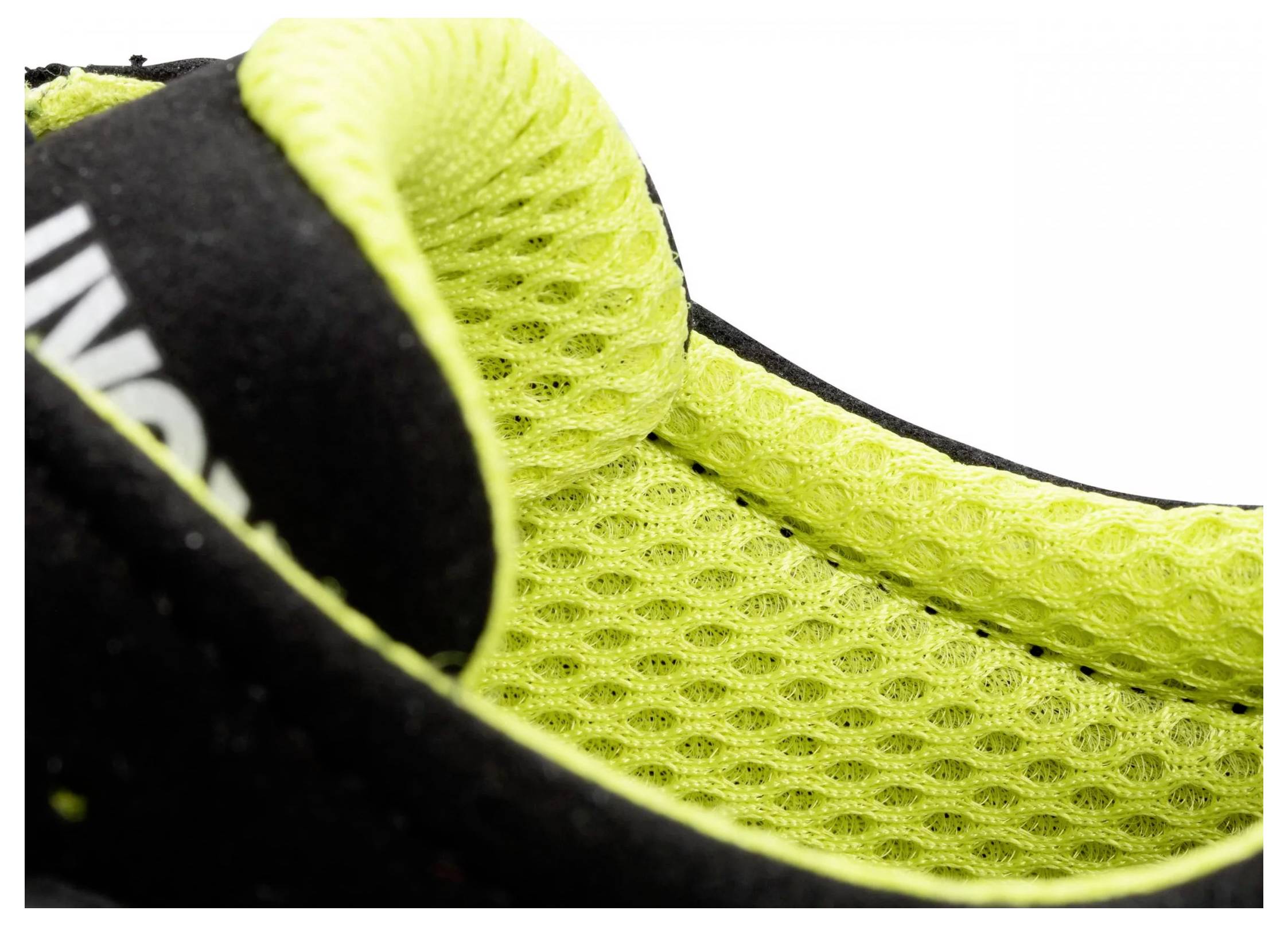 Close-up of a sports trainer with a yellow, breathable inner lining and a black outer material.