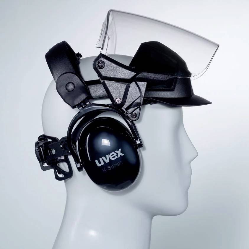 Protective helmet with a folding visor and integrated ear protection in black. Bearing the inscription 'uvex'.
