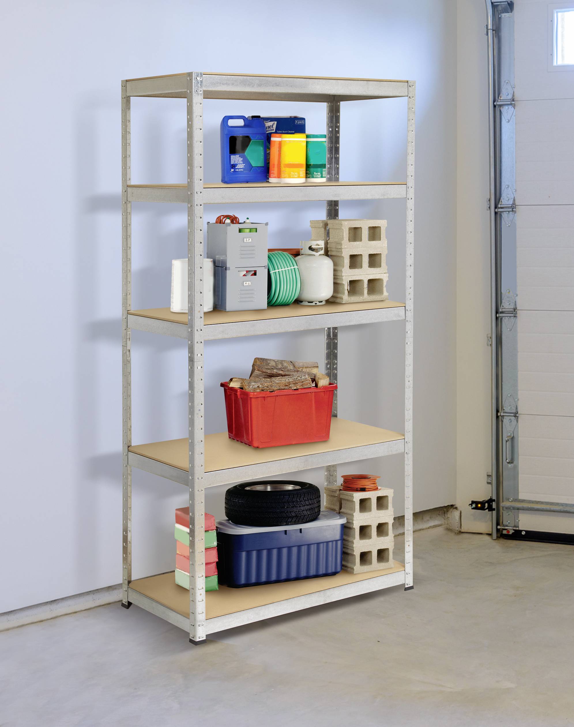 'Metal shelving unit in garage, laden with tools, paint buckets and car tyres. In the background a grey wall and a garage door.'