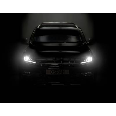 A black car with headlights switched on gleams in a dark environment. The number plate reads 'OSRAM'.