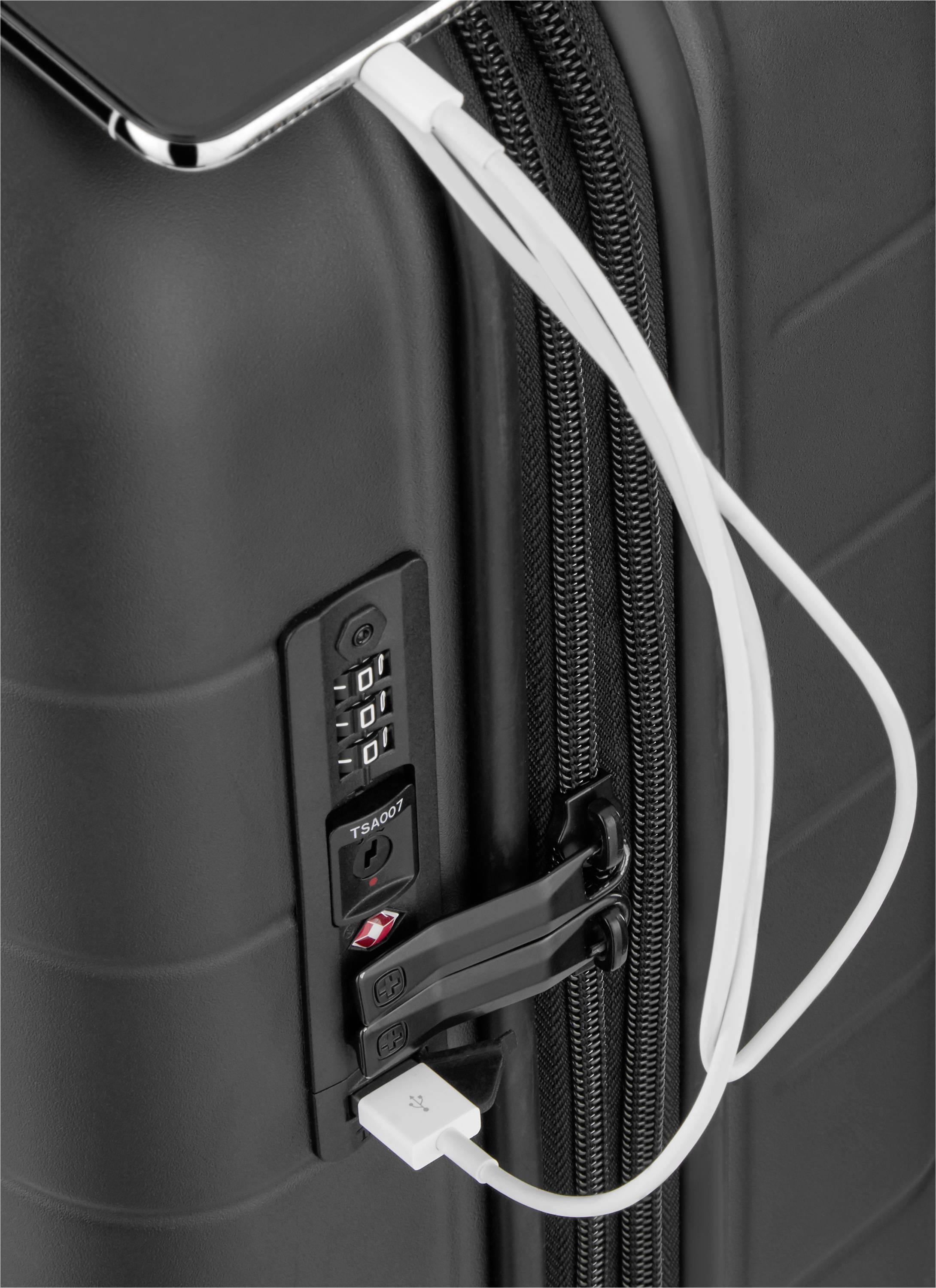 A black suitcase with an integrated TSA combination lock, with a charging cable connected, protrudes from a USB port.