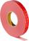 Roll of red double-sided adhesive tape with visible brand name and some tape unrolled.