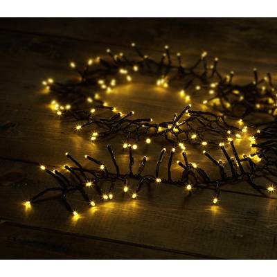 A string of fairy lights with warm white LED bulbs is draped loosely on a wooden table, creating a cosy and festive atmosphere.