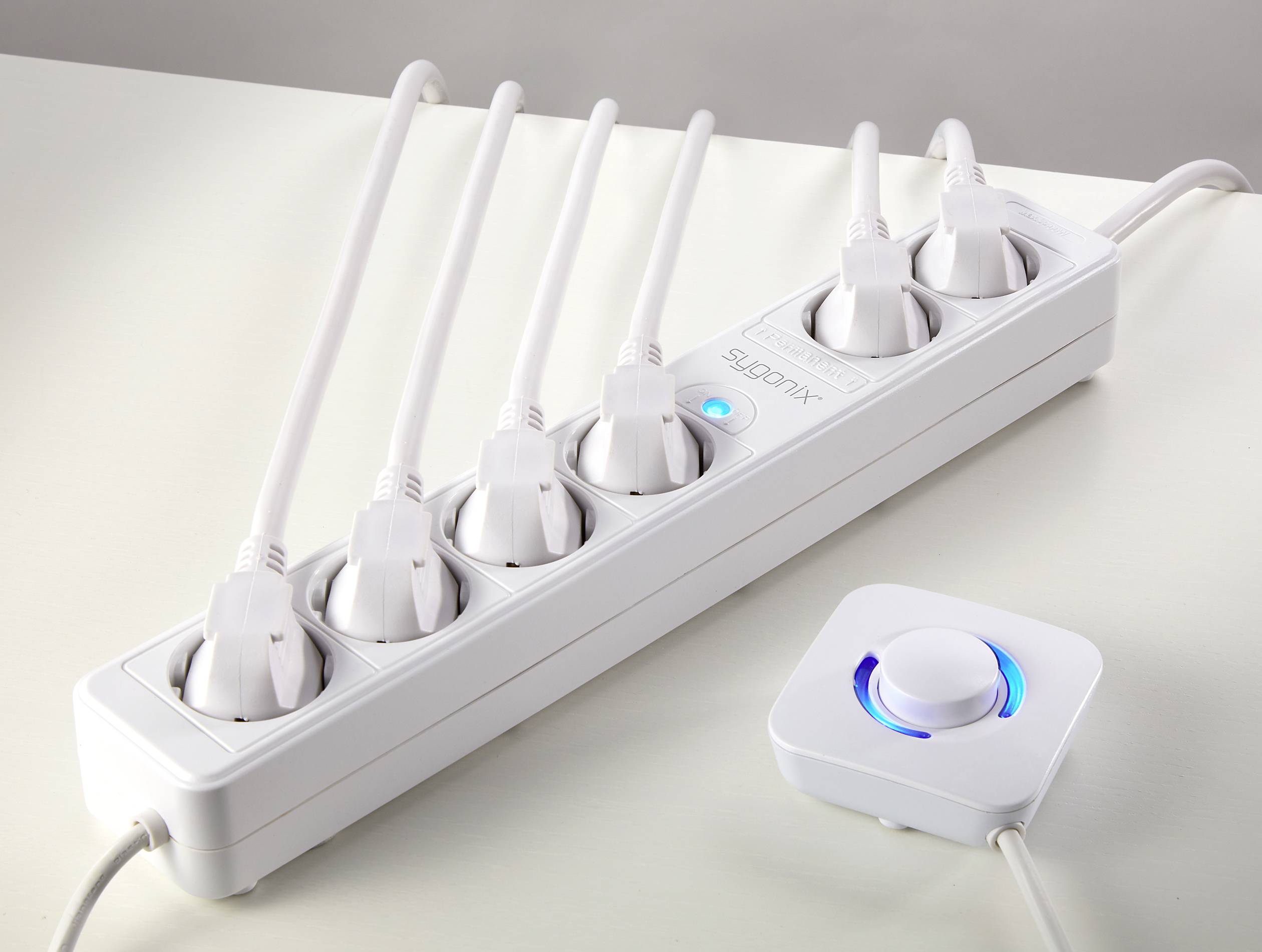 A white power strip with six plugged-in cables and a round, illuminated switch on the right-hand side.