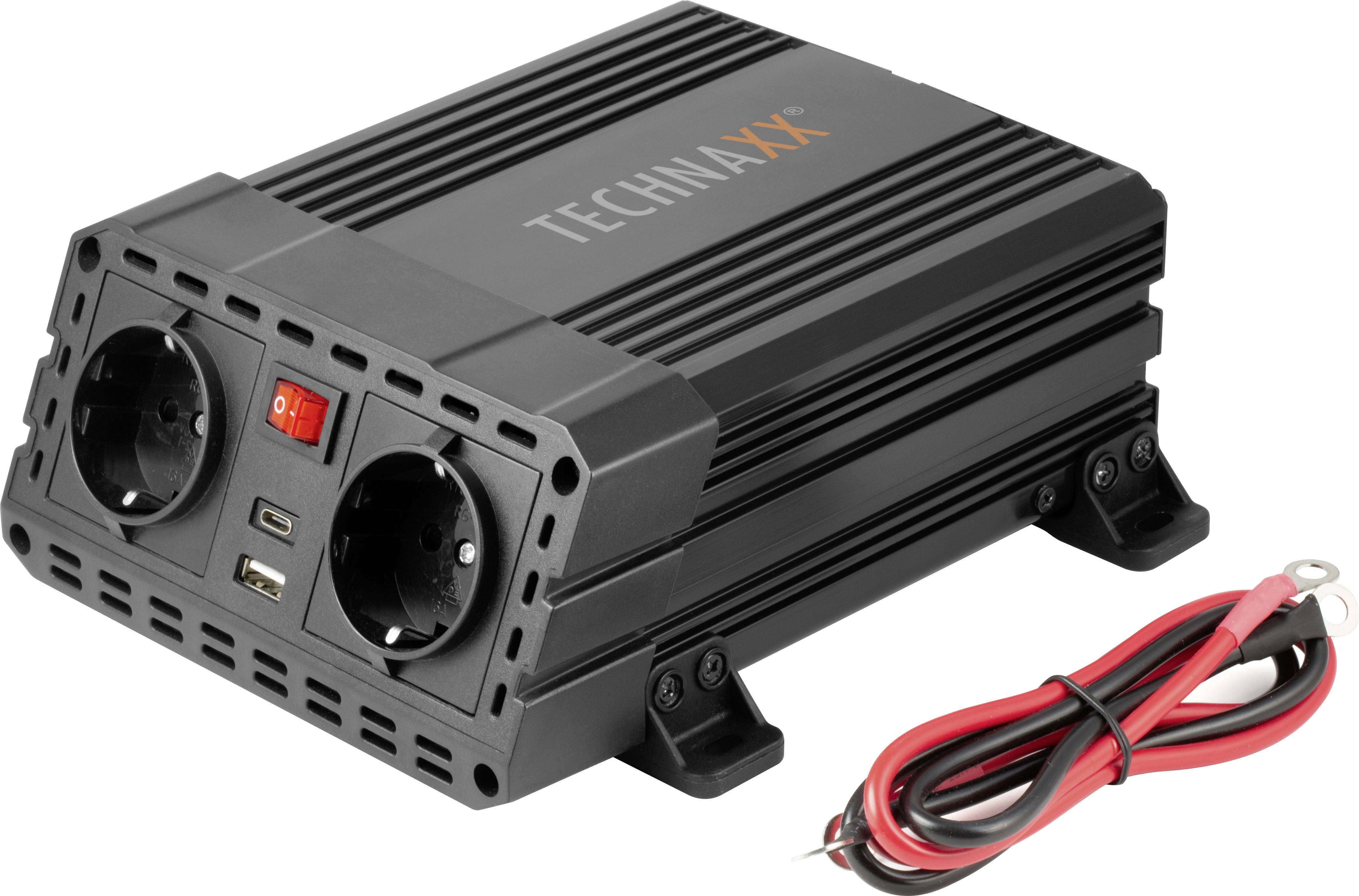 A black voltage converter with two plug sockets, USB ports and a switch. Beside it a cable with crocodile clips.