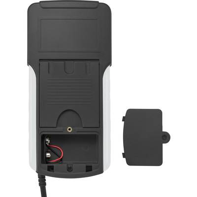 Back of an electrical device with an open battery compartment, an empty battery slot, and the removed cover placed beside it.