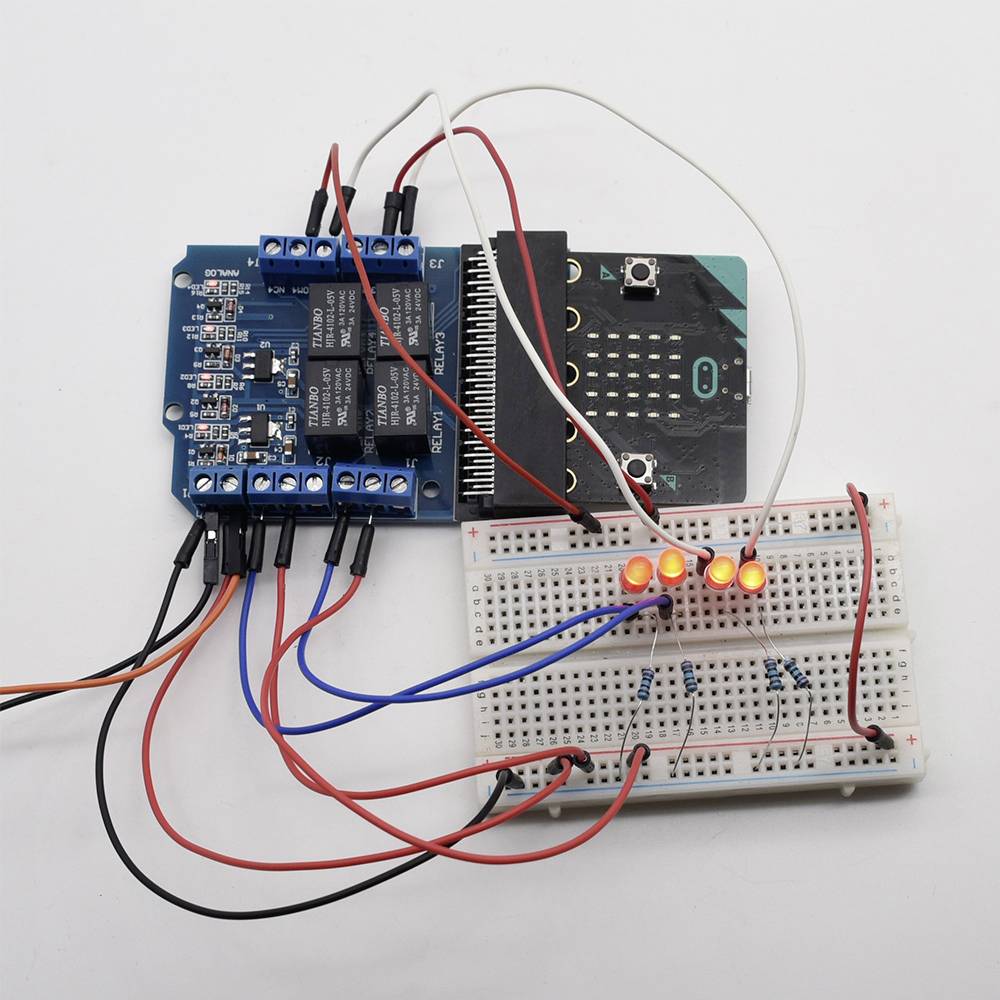 'Image shows an electronic circuit with a breadboard, wired microcontroller, and illuminated LEDs. Circuit is active.'