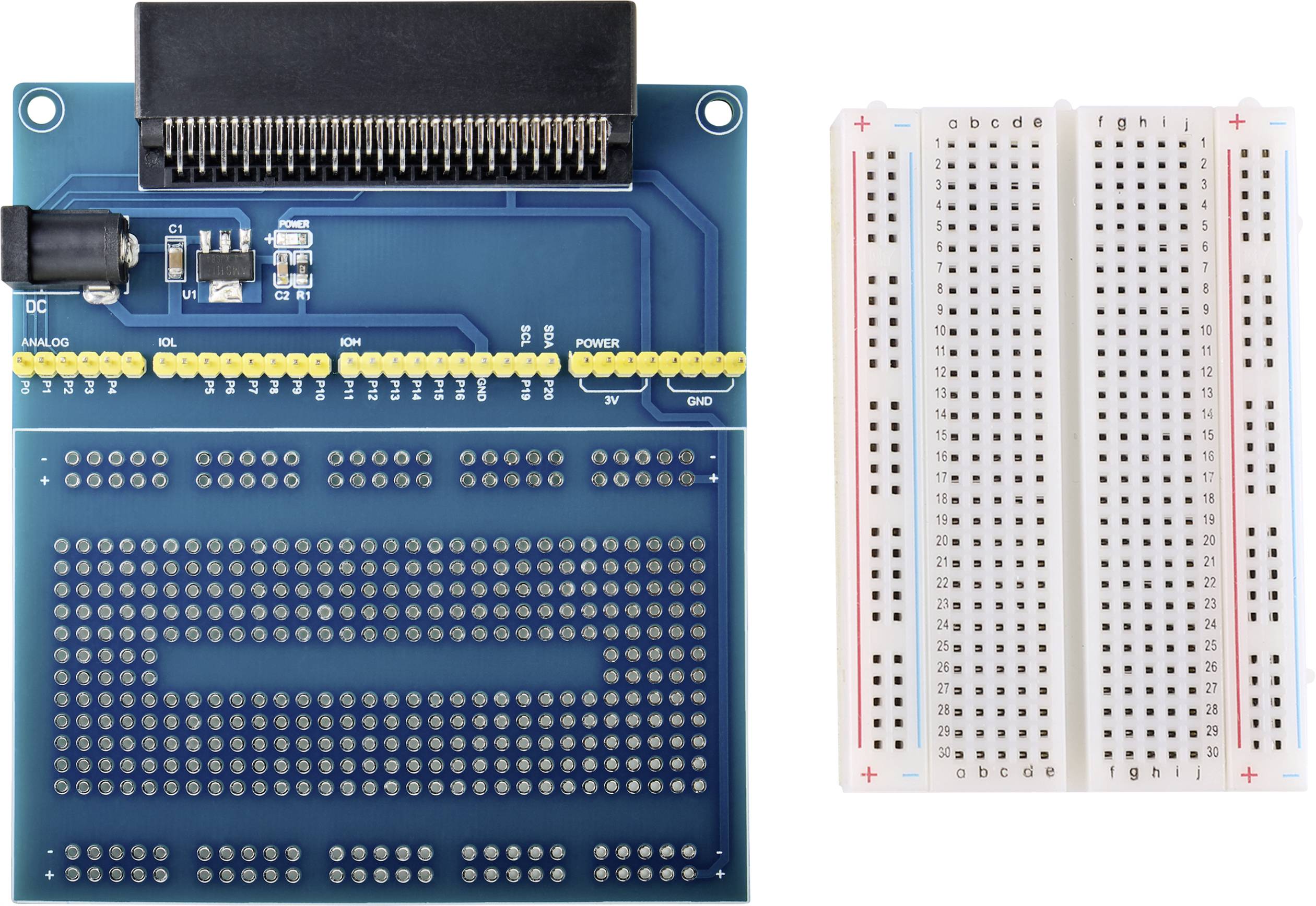 A printed circuit board beside a breadboard. The circuit board has soldered components, while the breadboard has letters and numbers marked.