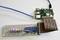 A circuit board with coloured LEDs is connected via cables to a Raspberry Pi, which is plugged into a blue network cable.