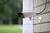 A security camera is mounted on a white brick wall. It is facing outwards, likely for security monitoring.