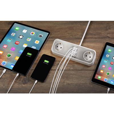 Tablet and smartphones are being charged simultaneously via an extension lead. All devices display their charging status.