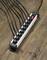 A power strip with eight black plugs connected lies on a wooden floor. A red switch is turned on.