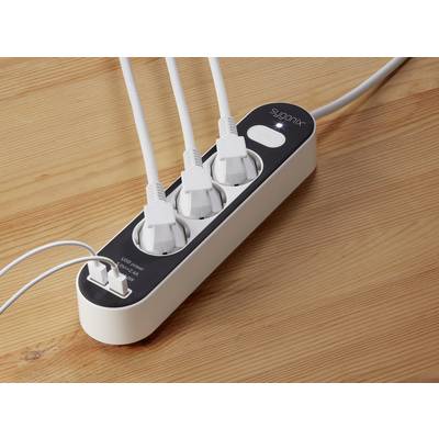 Three white plugs are inserted into a white power strip on a wooden table.