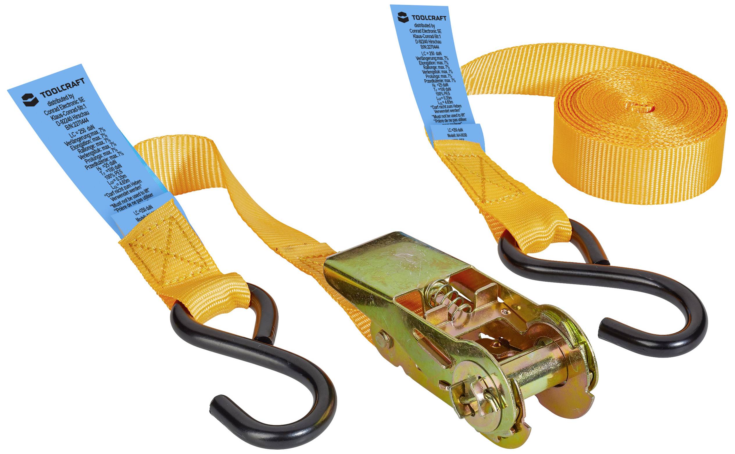 An orange lashing strap with a ratchet and hook is laid out. A blue safety label is attached.