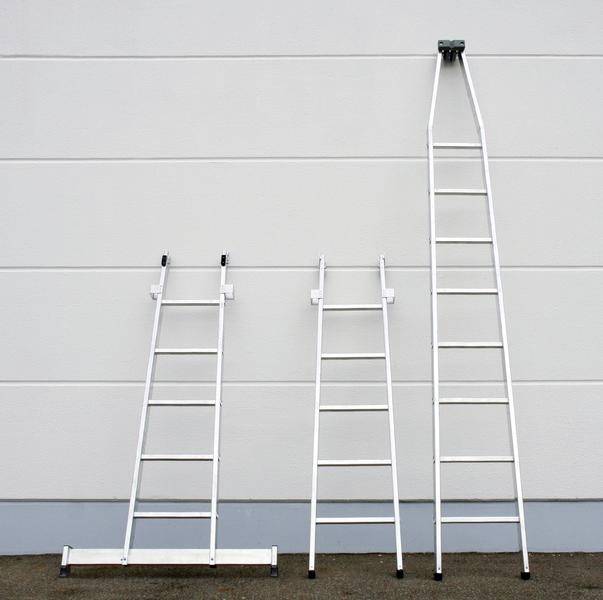'Three ladders of different sizes are leaning against a white wall.'