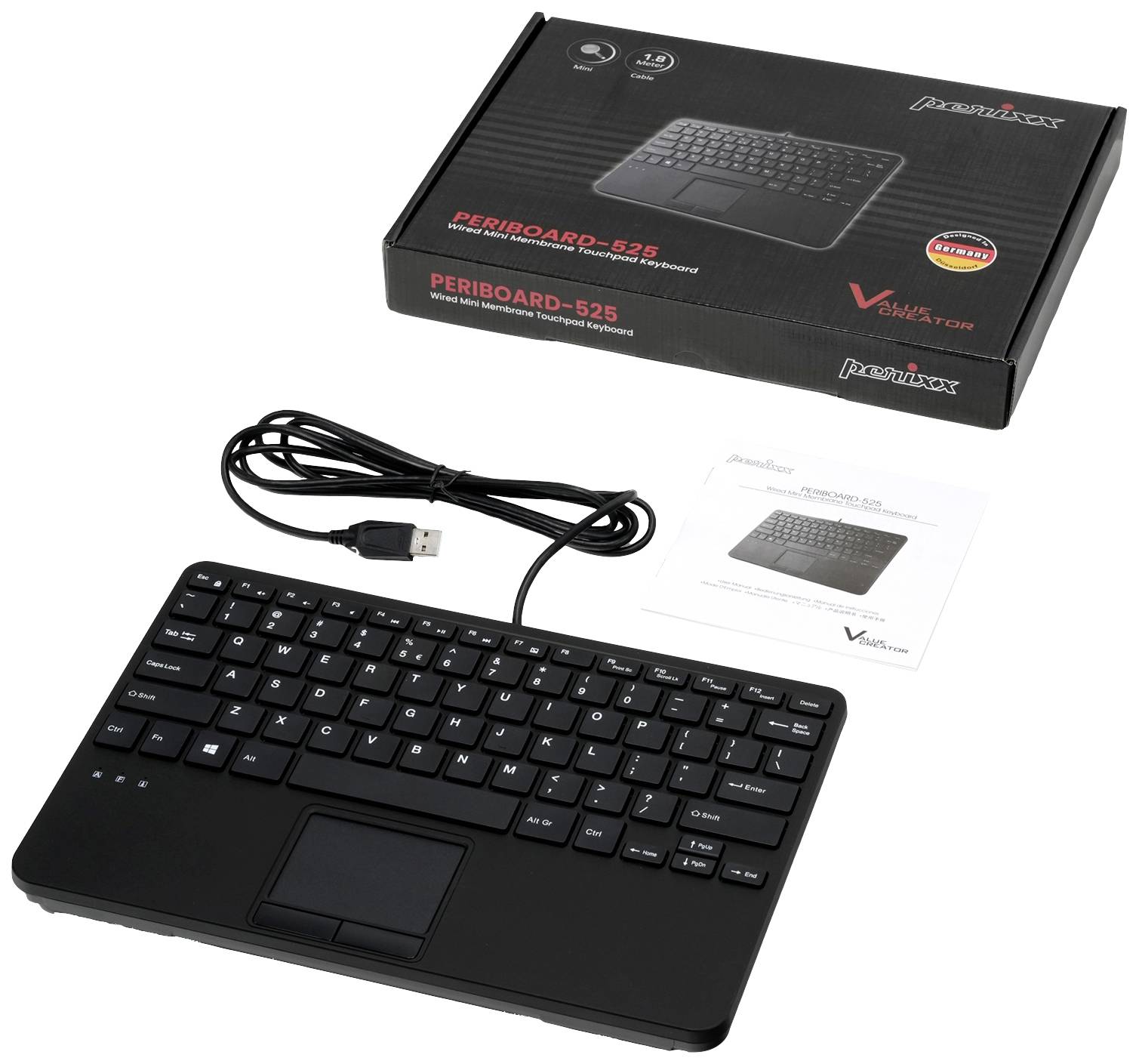 A black keyboard with a touchpad and USB cable lies beside its packaging and instruction manual on the table.
