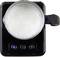 Milk Frother in Action: Top view of a milk frother with foamy milk in the container, black control panel with symbols.