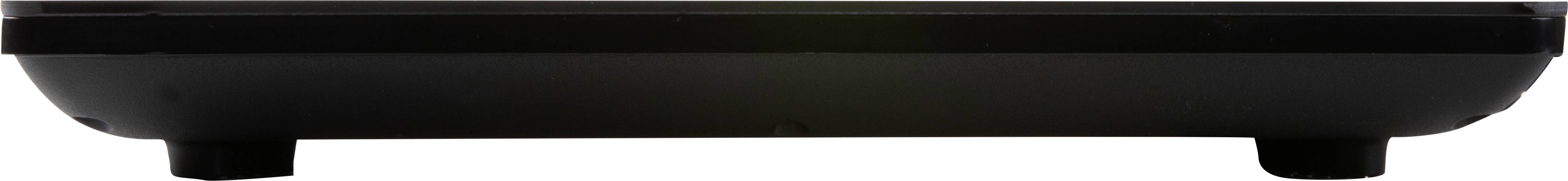 Close-up of a black, rectangular object with a flat base and short supporting feet, possibly an electronic device.
