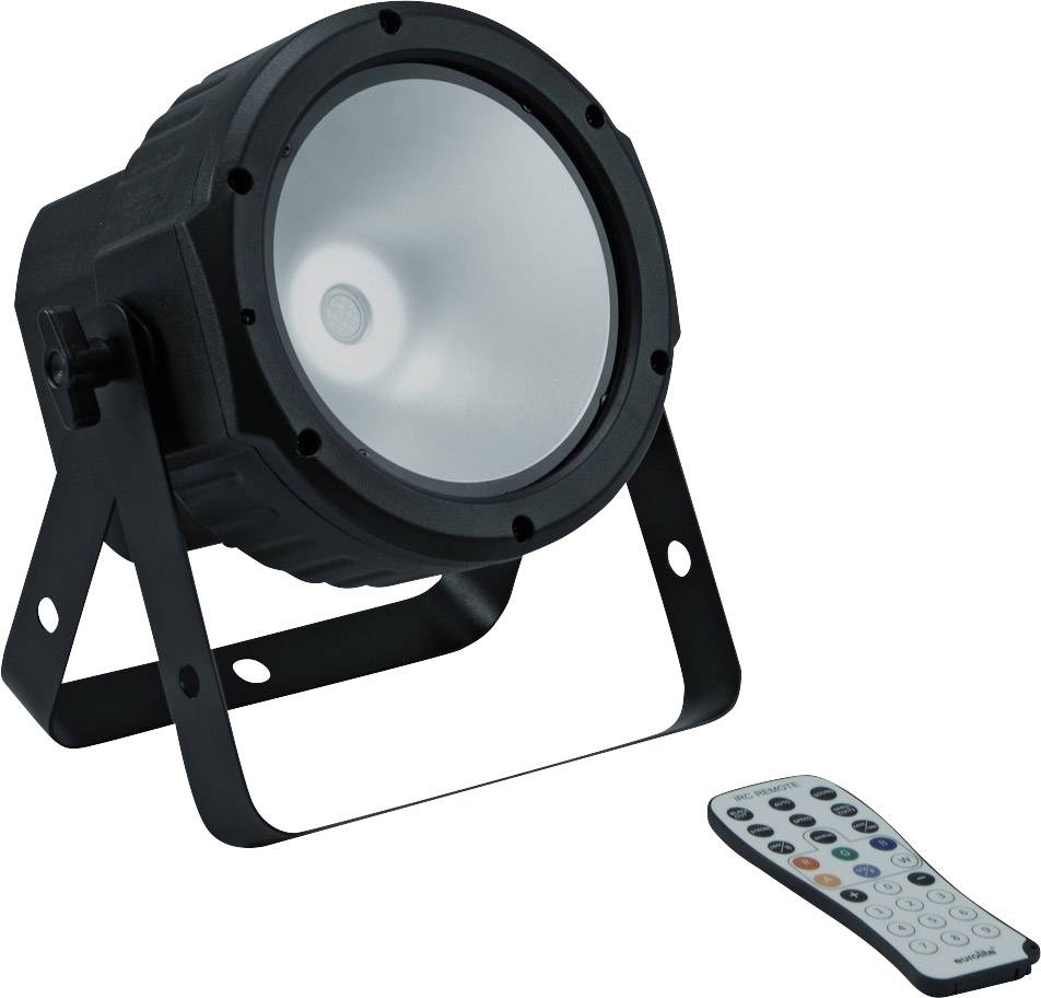 A black LED spotlight with a sturdy metal frame and a remote control with numerous coloured buttons lies beside it.