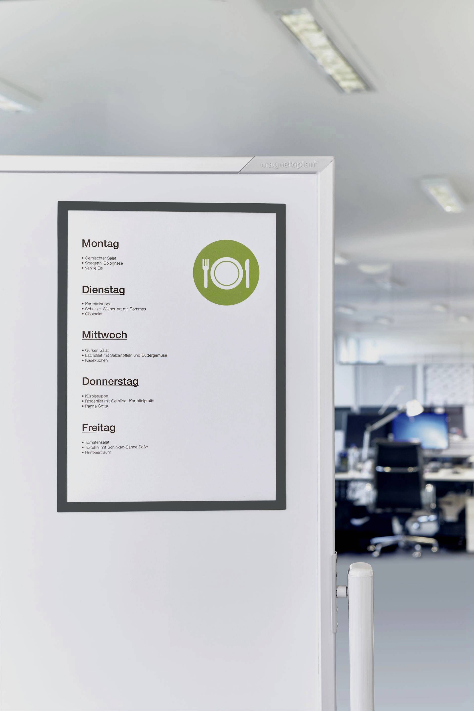 Menu board on an office wall displays the weekly menu: Monday to Friday with various dishes, next to a symbol with a knife and fork.