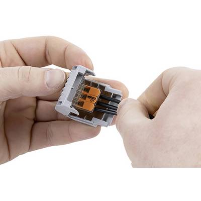Two hands connect cables with a grey and orange cable connector.