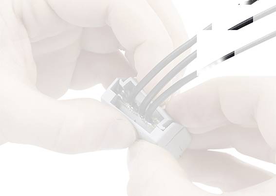 'Hands secure cables to an electrical connection.'