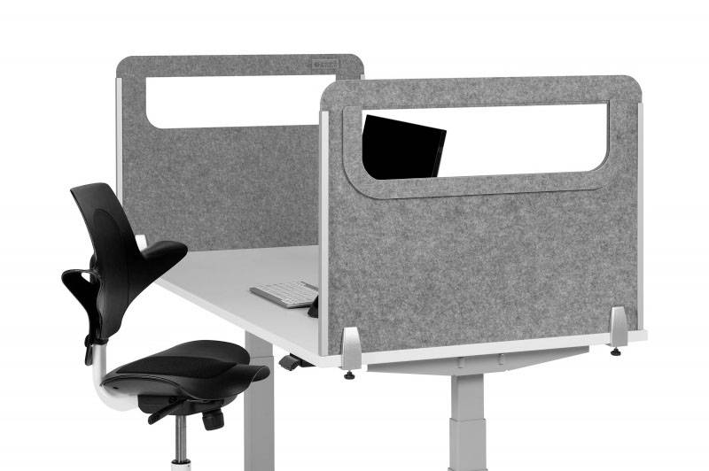 Height-adjustable desk with a grey privacy screen, an ergonomic office chair, with keyboard and monitor positioned on top.