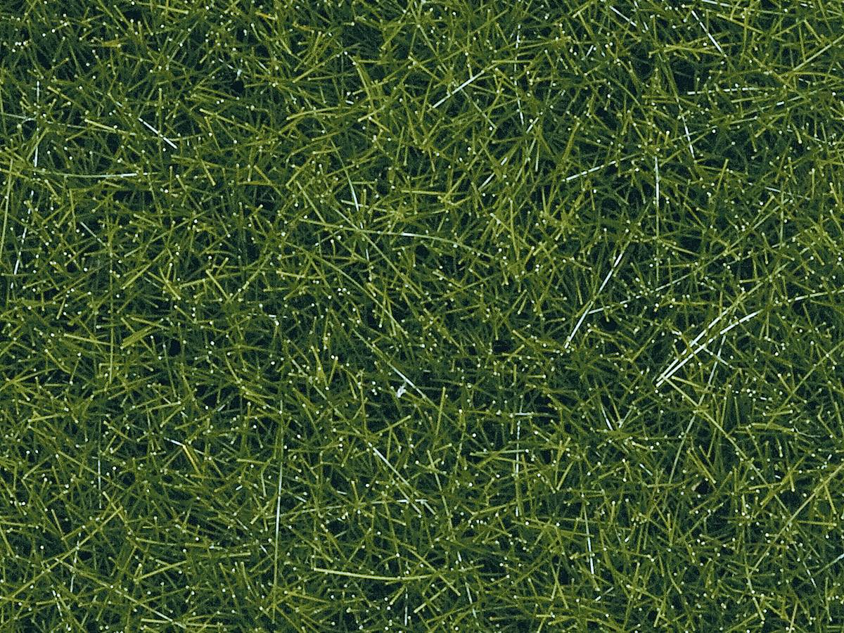 Close-up of green, dense artificial grass with a fine texture and moist sheen, mimicking a natural grass surface.
