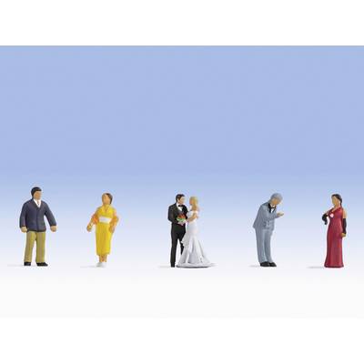 Several miniature figurines in various coloured outfits are standing on a white surface against a blue background.