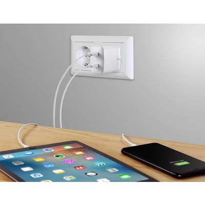 A tablet and a smartphone are being charged via a dual charging adapter plugged into a socket, both displaying charging symbols.
