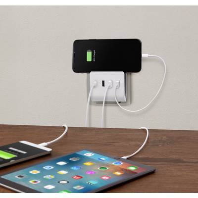 A smartphone and a tablet are being charged via USB cables. The smartphone displays a green charging indicator, showing that it is charging.