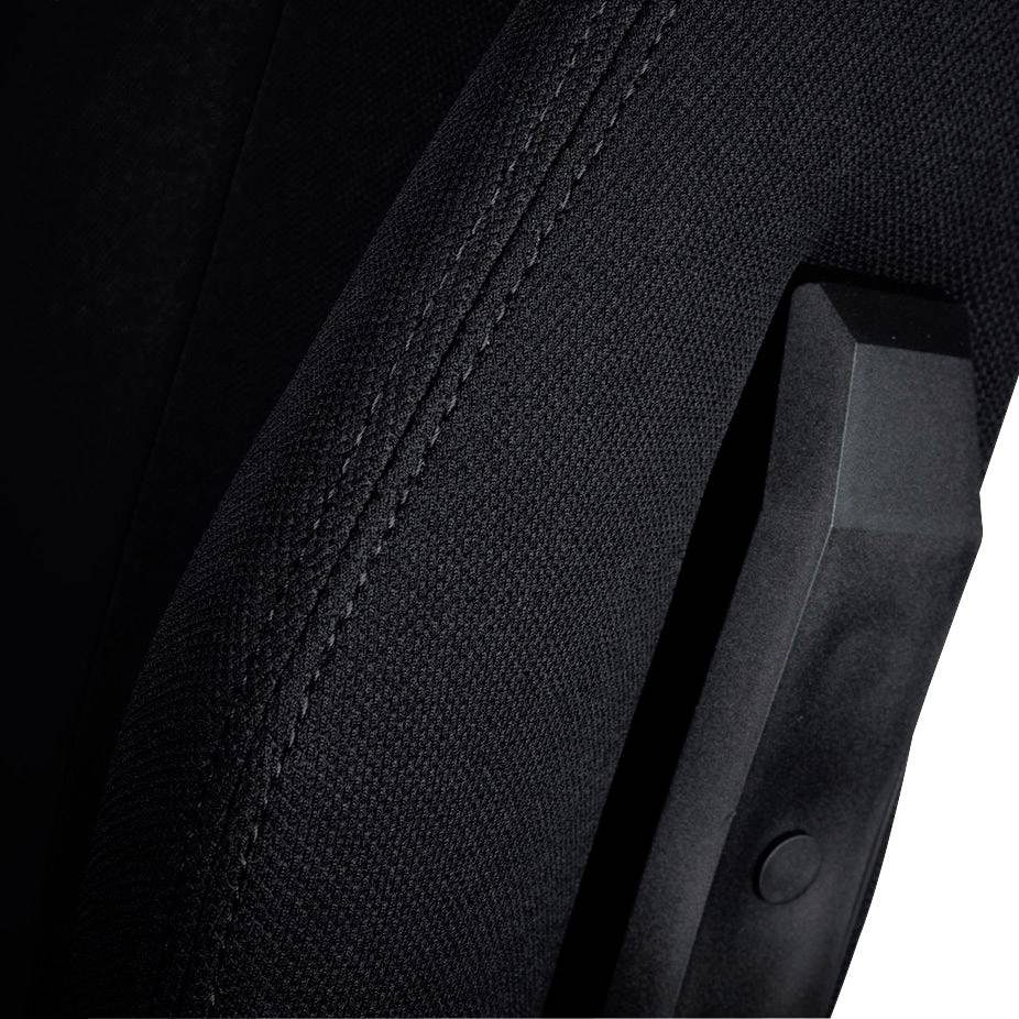 Close-up of a black fabric surface with a textured edge and a black armrest element of a chair.