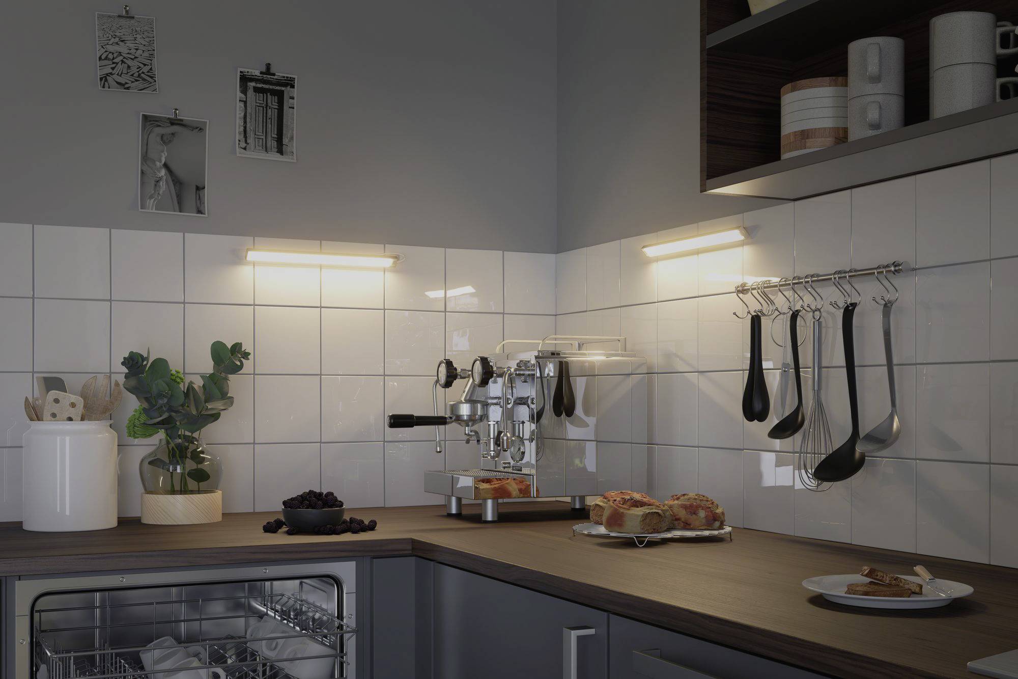 Modern kitchen with a coffee machine, decorative plants and crockery on the worktop, illuminated by warm light.
