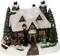 A snow-covered house with a glittering roof. On the left, a sleigh carries Father Christmas and a reindeer. On the right, a decorated Christmas tree stands.