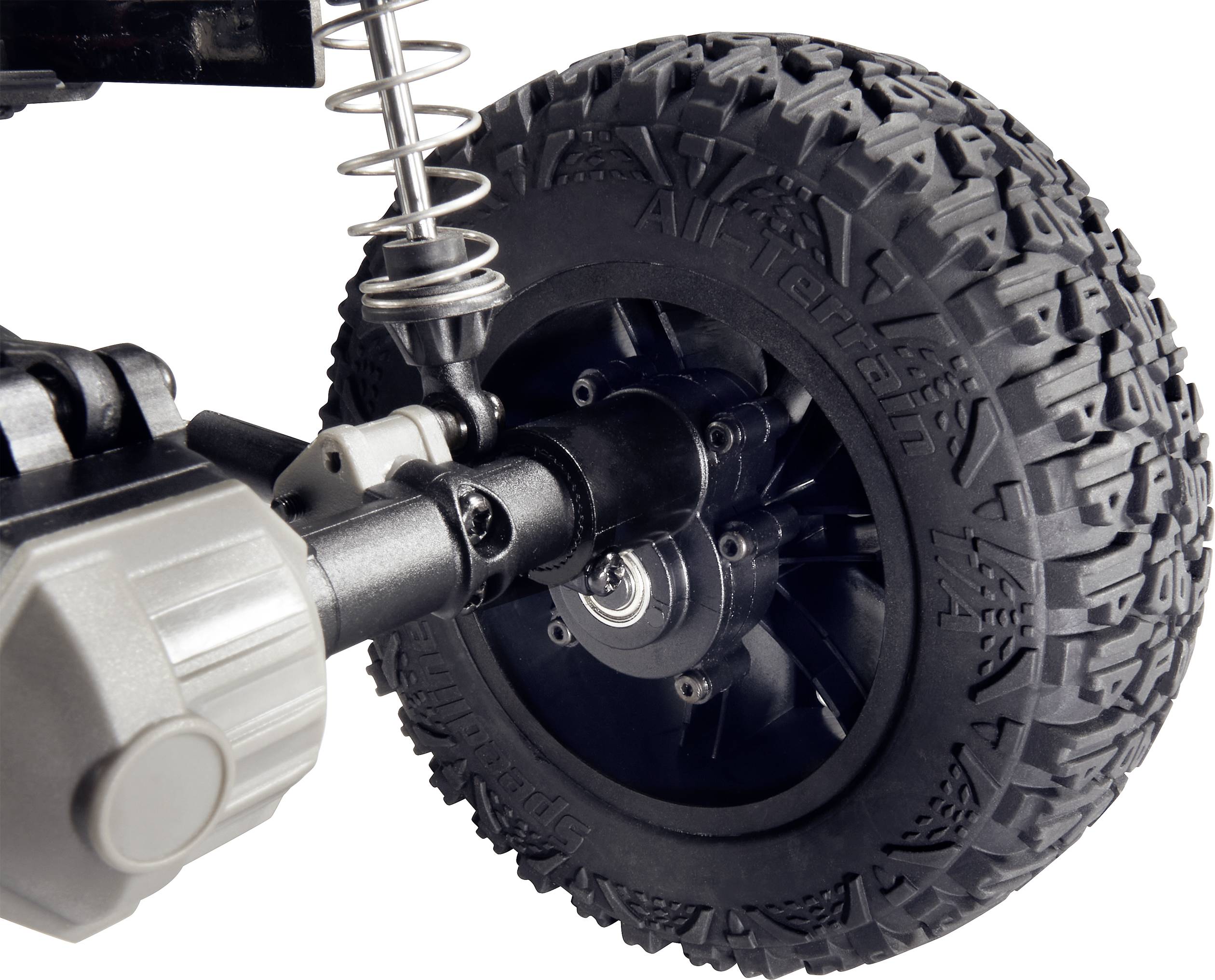Close-up of an all-terrain tyre and suspension of a remote-controlled vehicle, demonstrating robust design for challenging terrain.