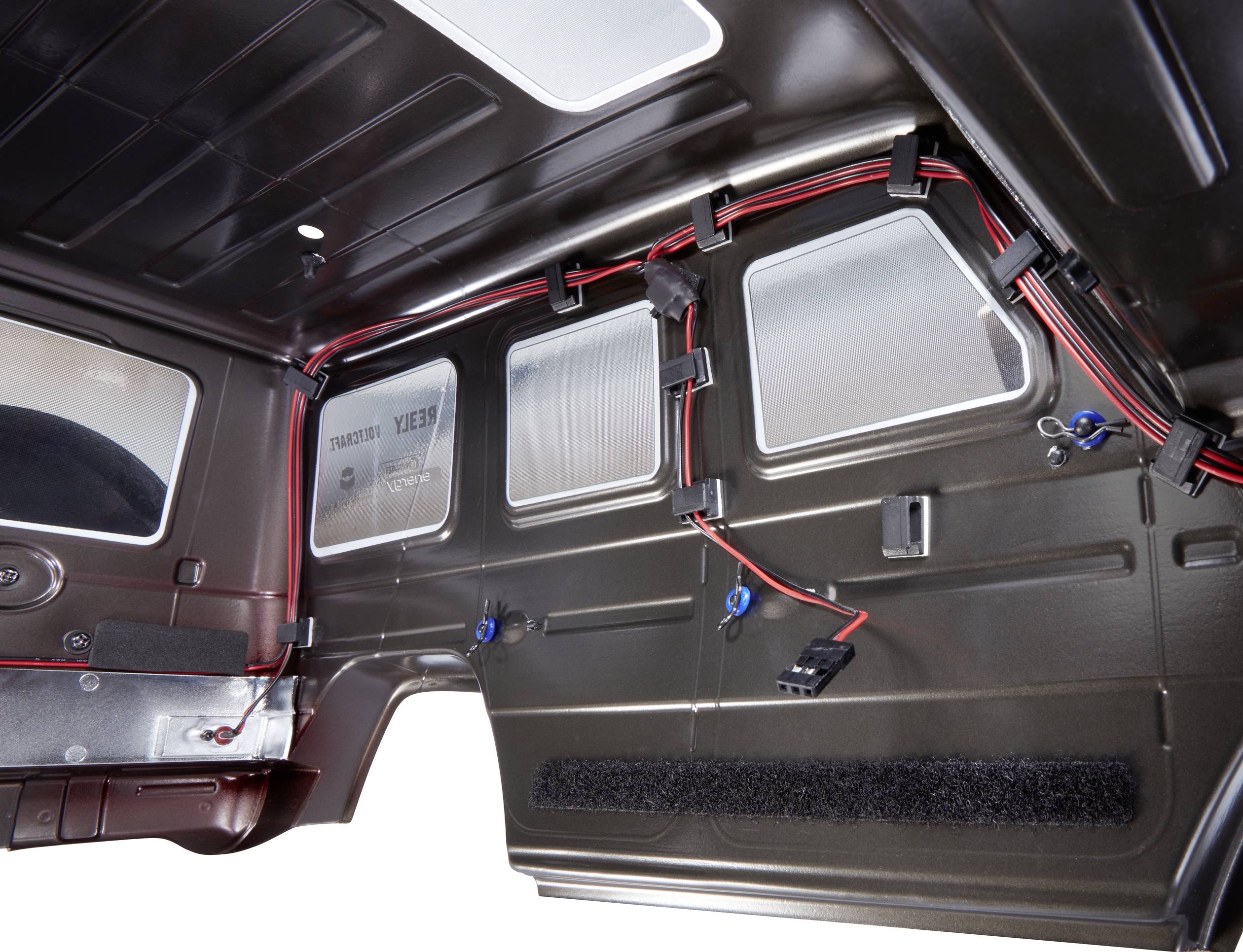 Interior view of a vehicle, showing the wiring and mounting elements on the interior trim of a vehicle door.