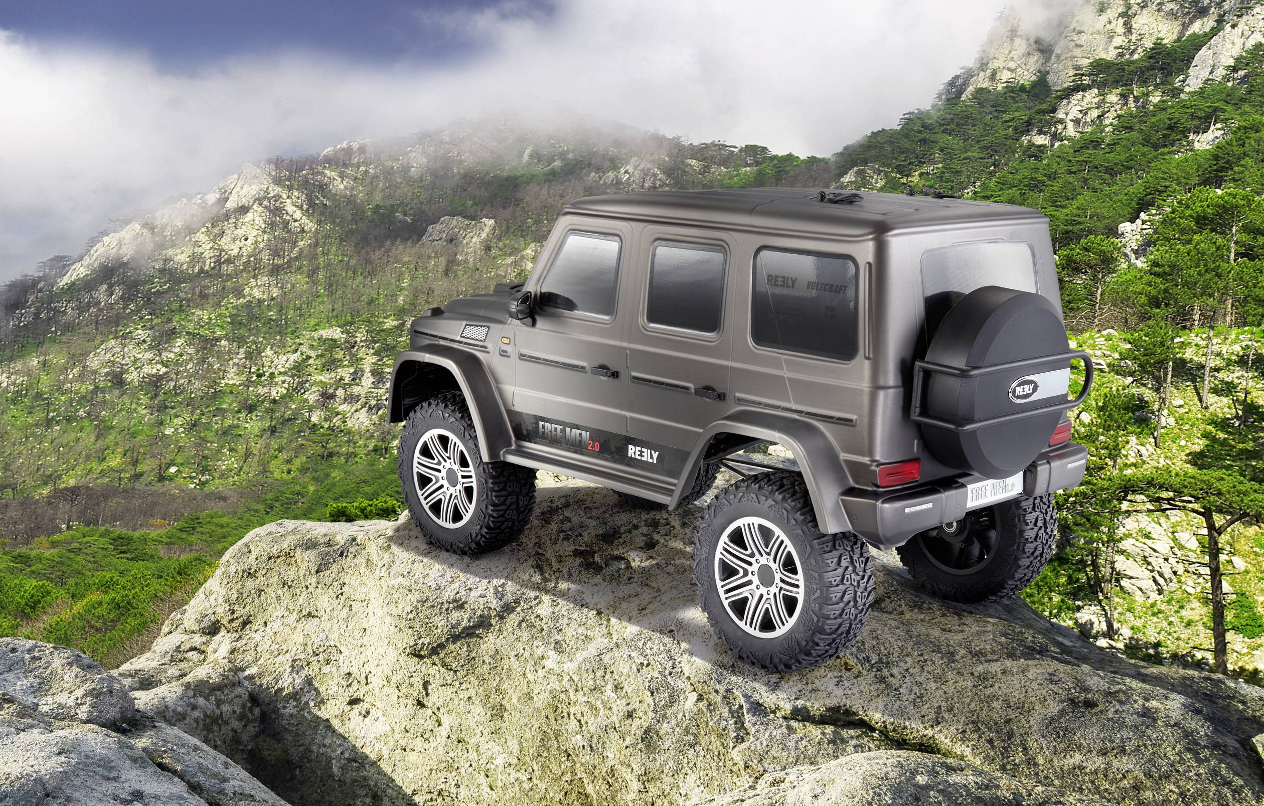 A 4x4 vehicle stands on a rocky mountain with forested hills in the background, ready for an off-road expedition.