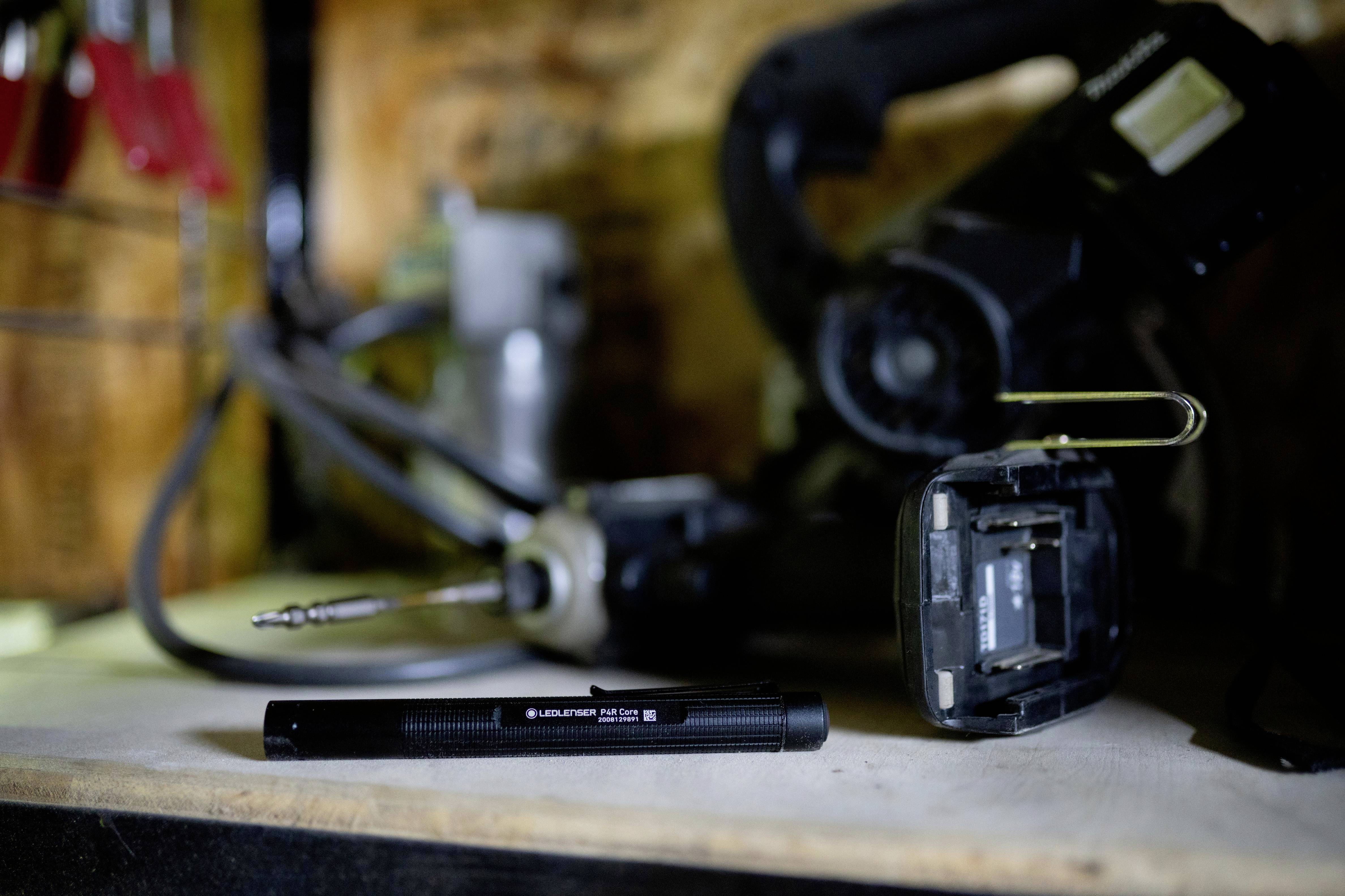 A workbench shows a torch in the foreground, alongside a drilling tool, suggesting a craftsman's environment.