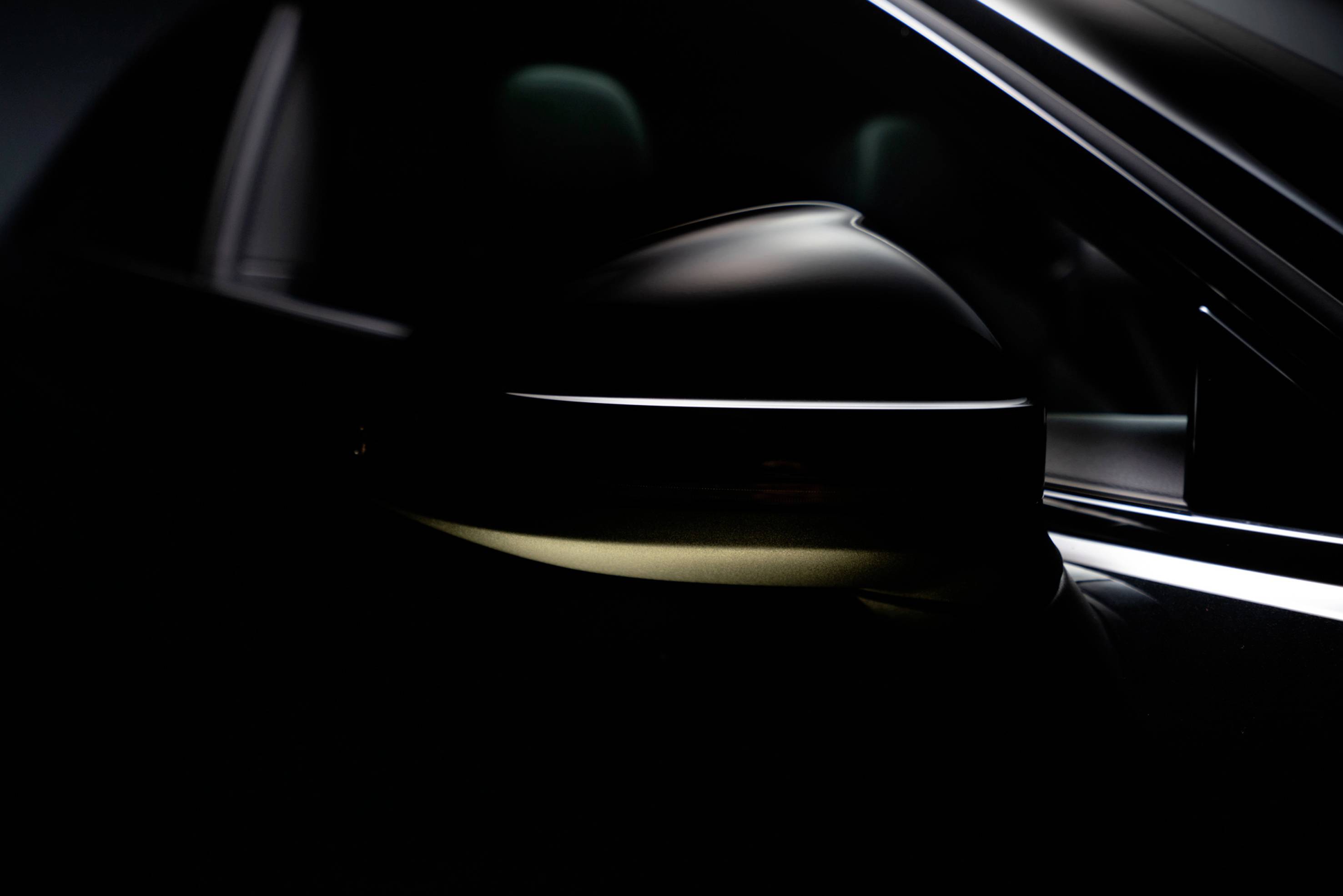 A close-up image of a car wing mirror with a gleaming surface reflecting light, showcasing modern design aesthetics.