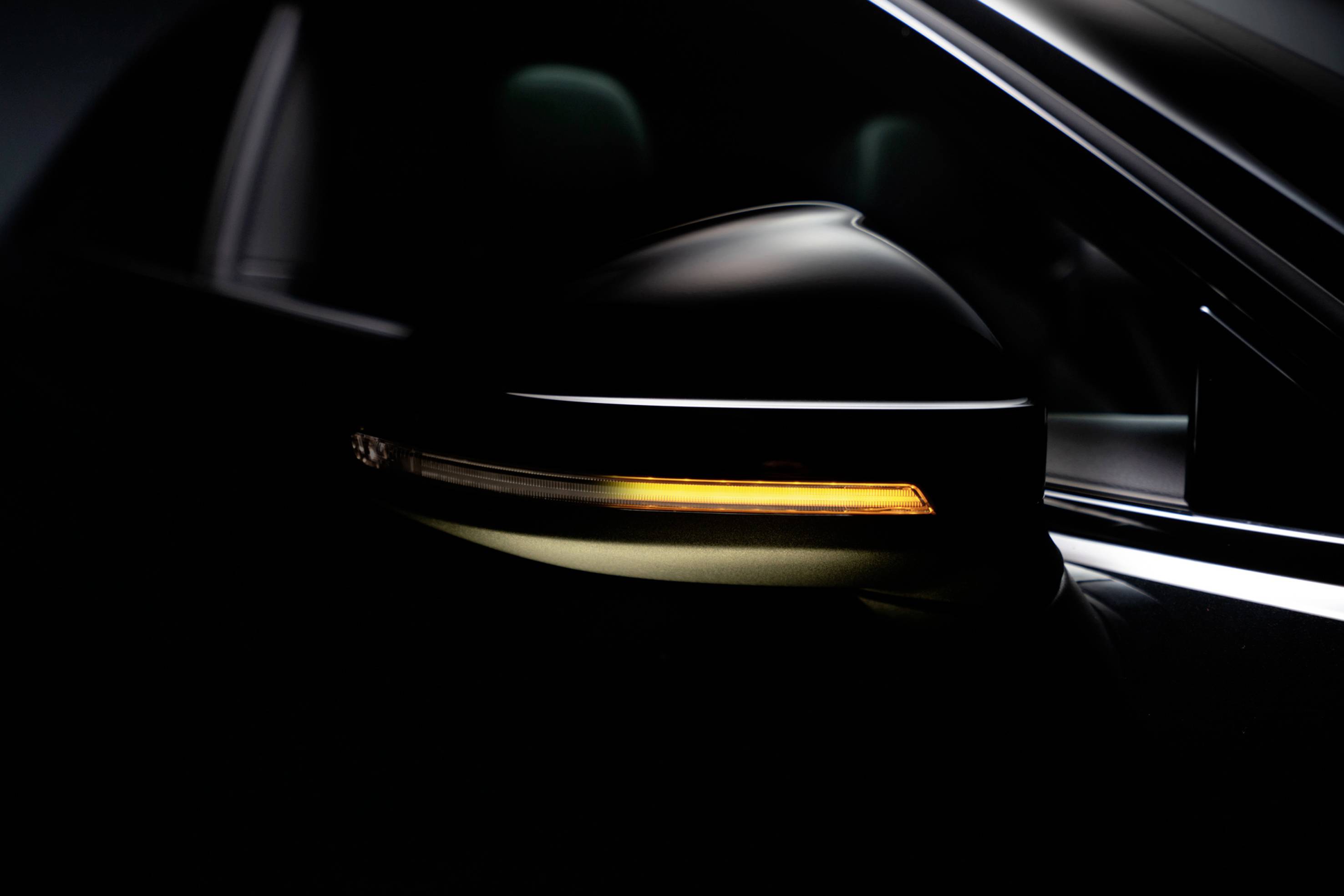 Side mirror of a car with a glowing indicator showing timely preparation to turn.