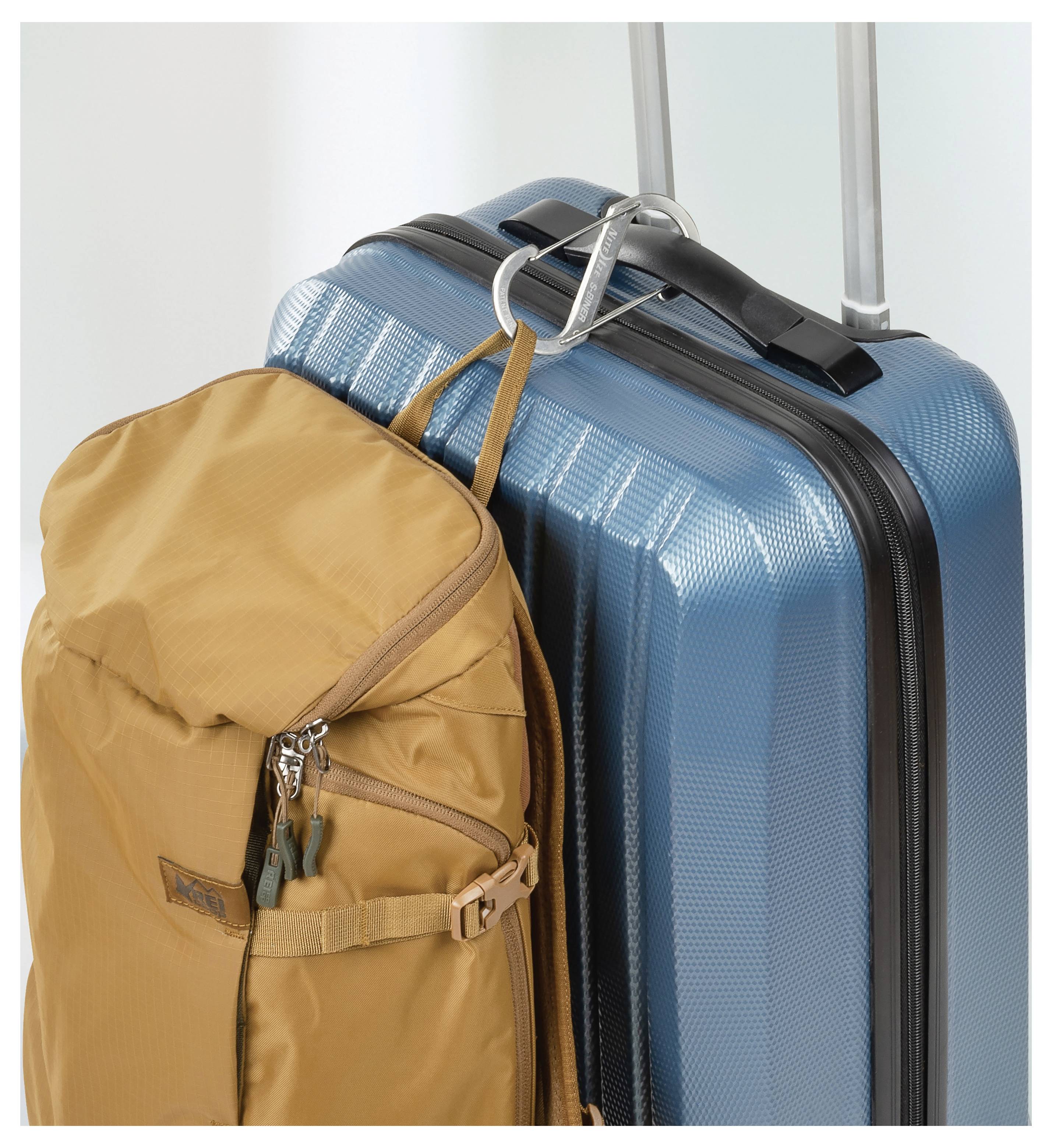 A blue hard-shell suitcase with an orange backpack attached, indicating travel or readiness for a trip.