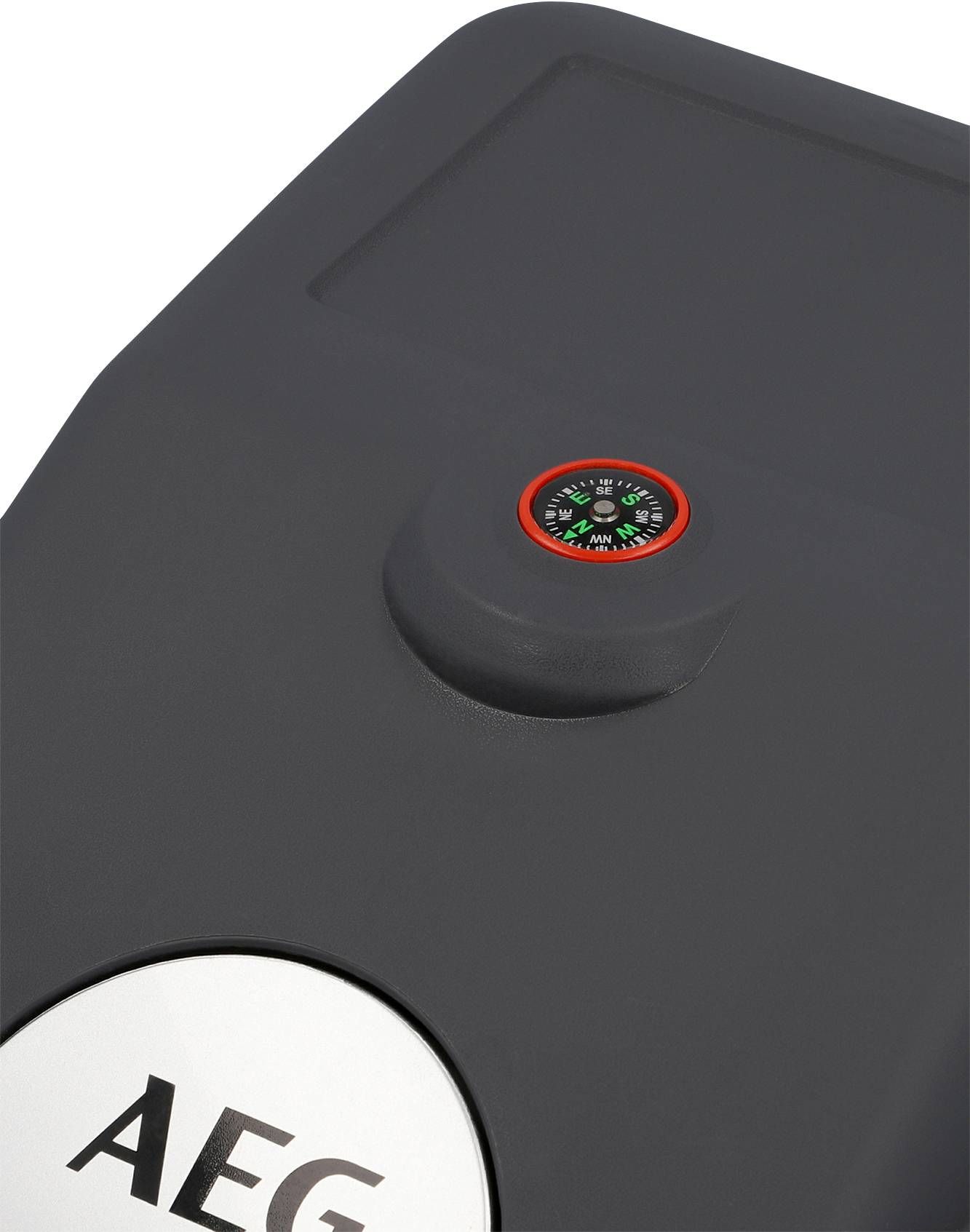 A dark grey vacuum cleaner lid with a compass on the top surface, with the logo of a well-known manufacturer beneath it.