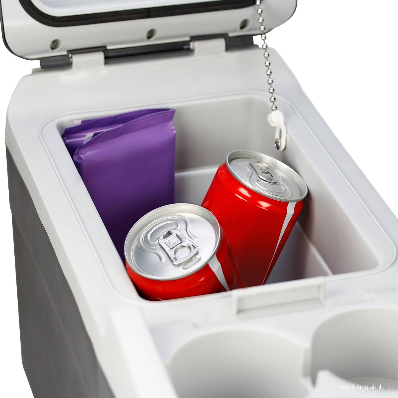 Two red drinks cans and a purple cool pack are lying in an open refrigerator compartment of a car.
