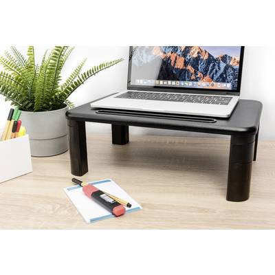 A laptop sits on a black desk stand. Next to the table, there is a pot with a plant and office supplies.