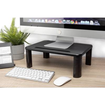 A desk with a computer screen on a monitor stand, alongside a keyboard, a mouse, and a plant.